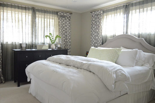 A well-designed master bedroom in various neutral shades including white, gray, and black