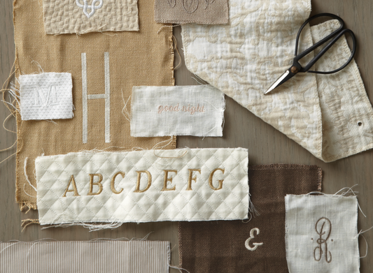 Embroidery samples in creams and browns on various types of fabric