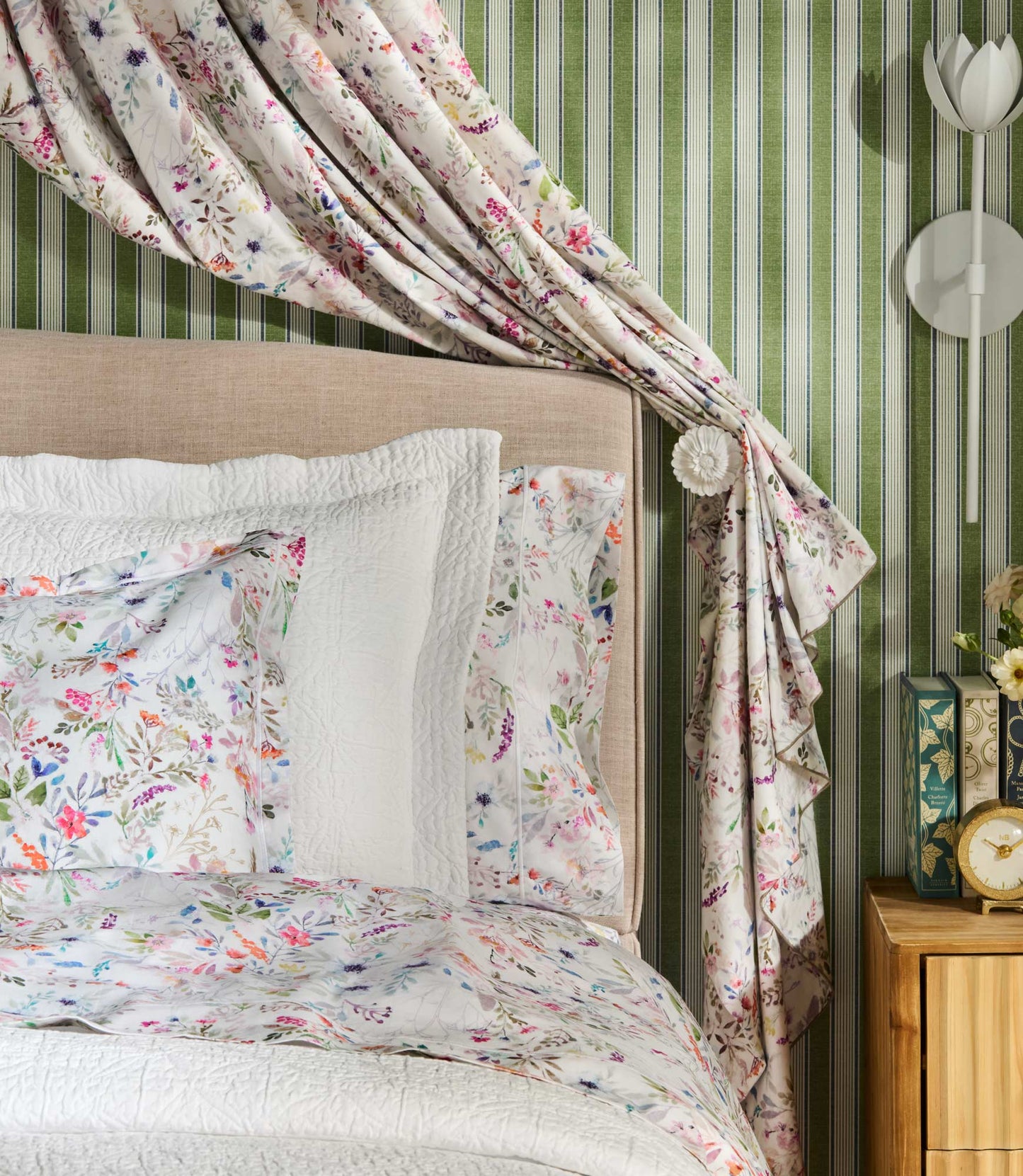 Close up of chloe percale shams on a bed against a draped, green accent wall
