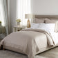 Angelina Platinum Coverlet and Shams on a neutral upholstered bed