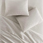 Houndstooth Percale Sleeping Shams and sheets on bed Greige