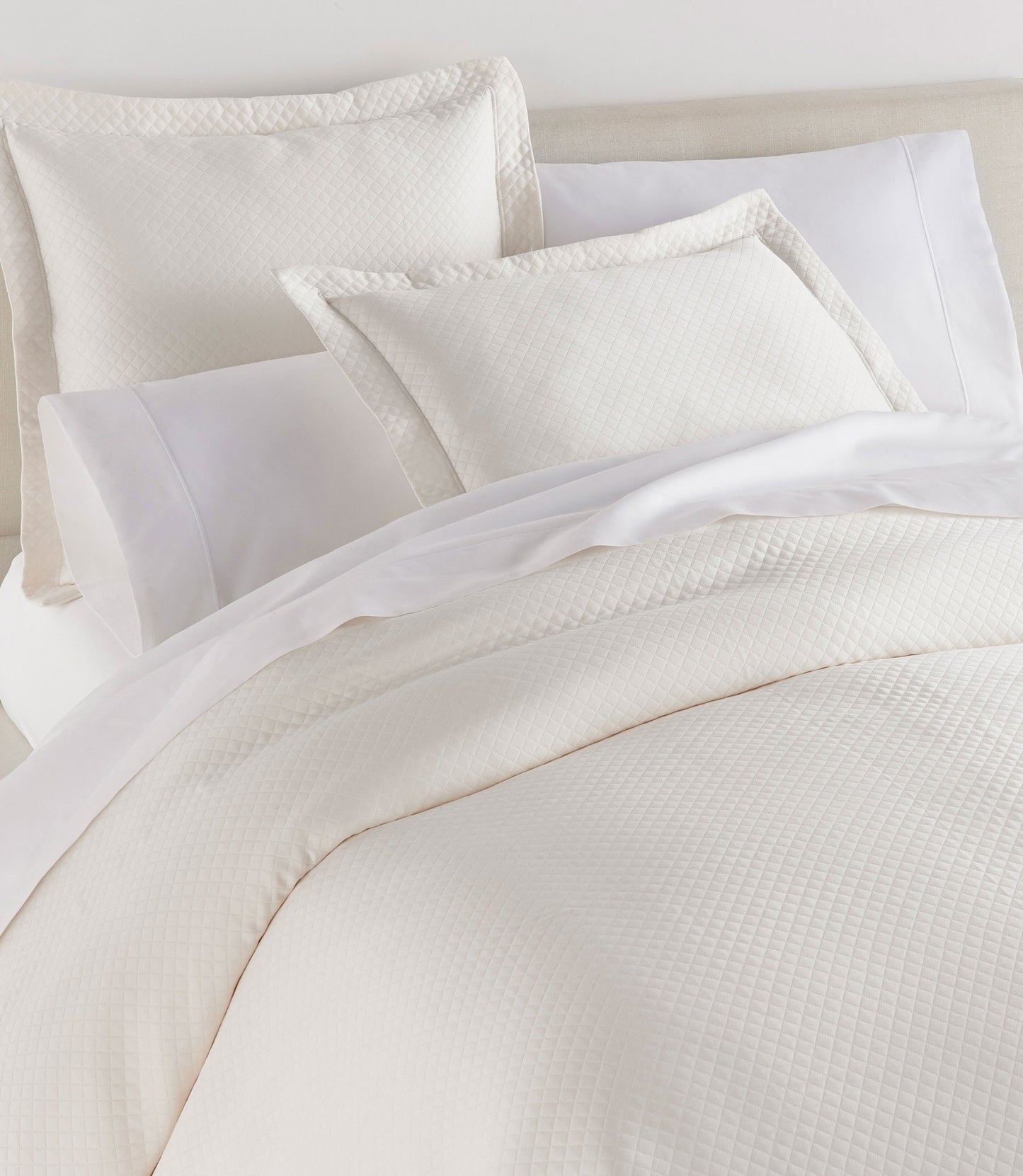 Oxford Matelassé Shams on bed Ivory