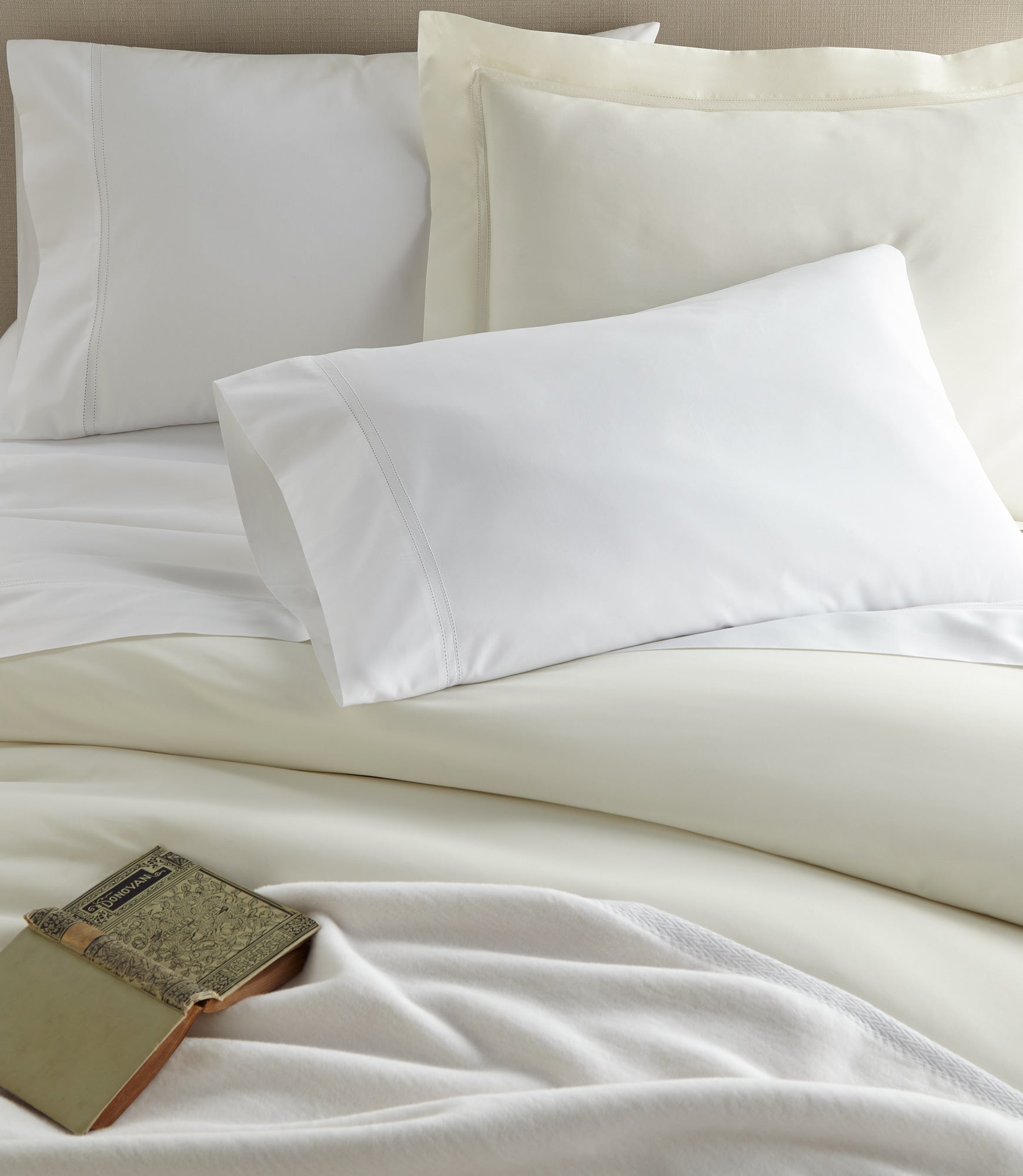 Virtuoso Sateen Sheet Set Ivory and White on a Bed