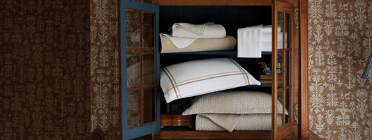 luxury bedding stacked in a hall cabinet