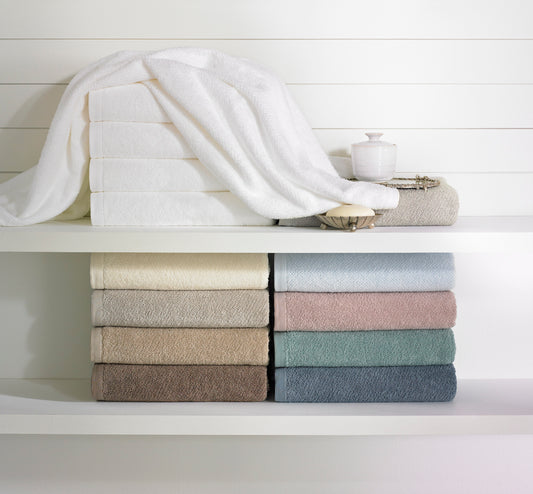 Folded towels in various colors against a white board background