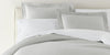 Montauk Matelassé Bedding Set in Gray layered with crisp, white sheets.