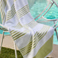 Aegean Stripe Beach Towel laying over a white pool chair, Lime