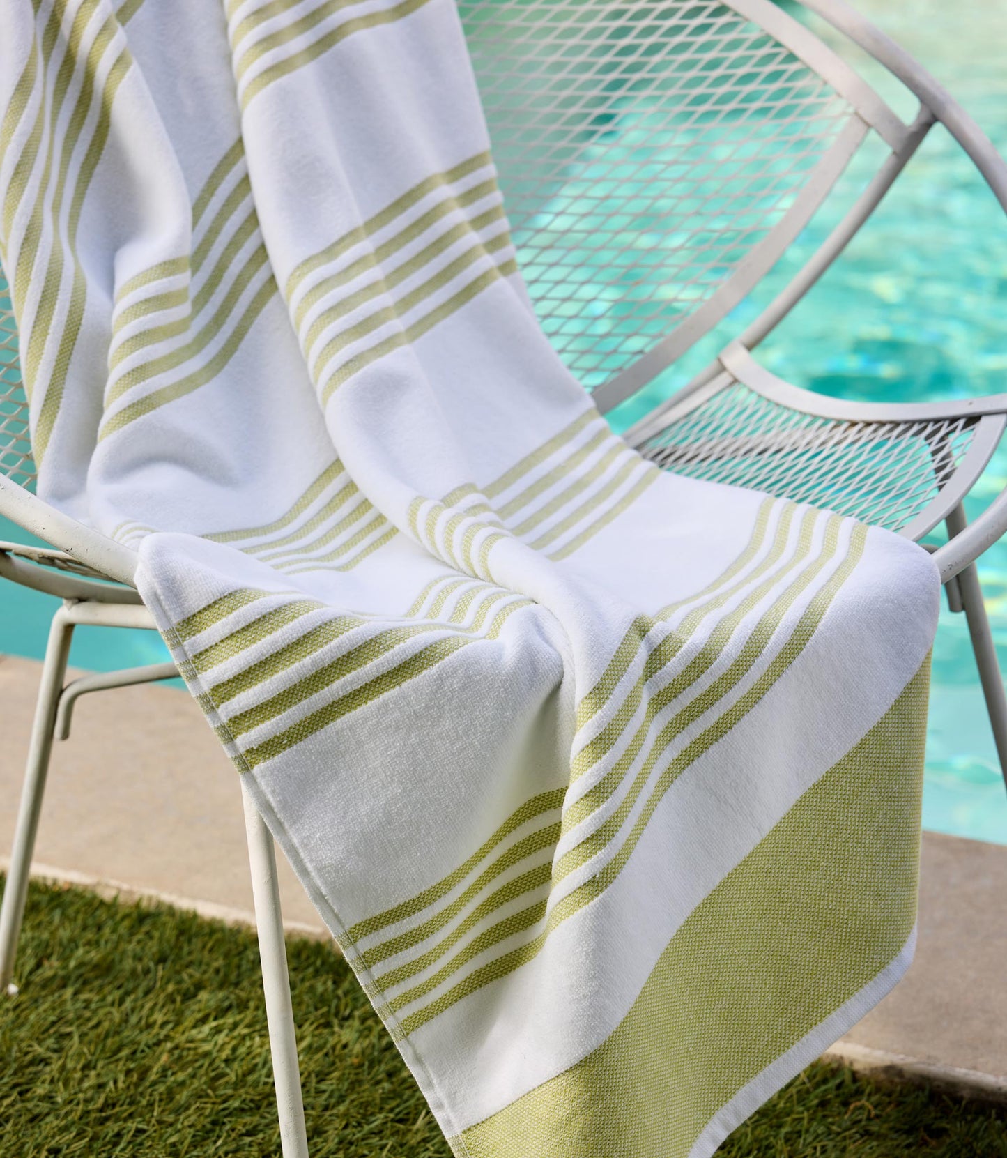 Aegean Stripe Beach Towel laying over a white pool chair, Lime