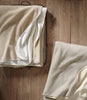 Folded Alta Reversible Cotton Blanket On Table White Pearl Colors