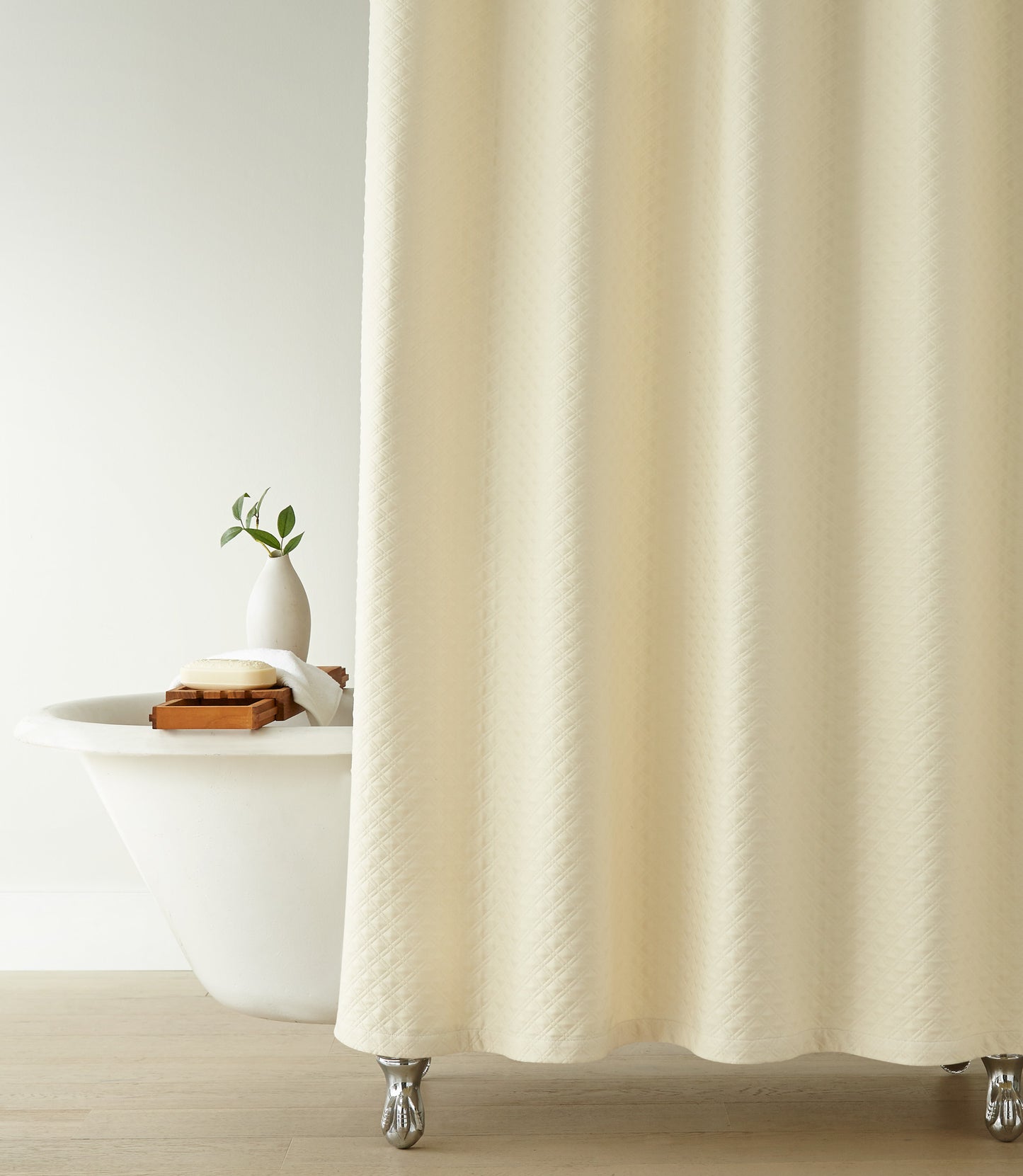 Alyssa Matelassé Shower Curtain in a bathroom setting with a bathtub and plant, Natural