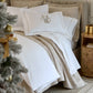Vienna Coverlet displayed on a bed with an embroidered white sham