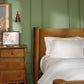 Clara cotton duvet set on bed in green room, White