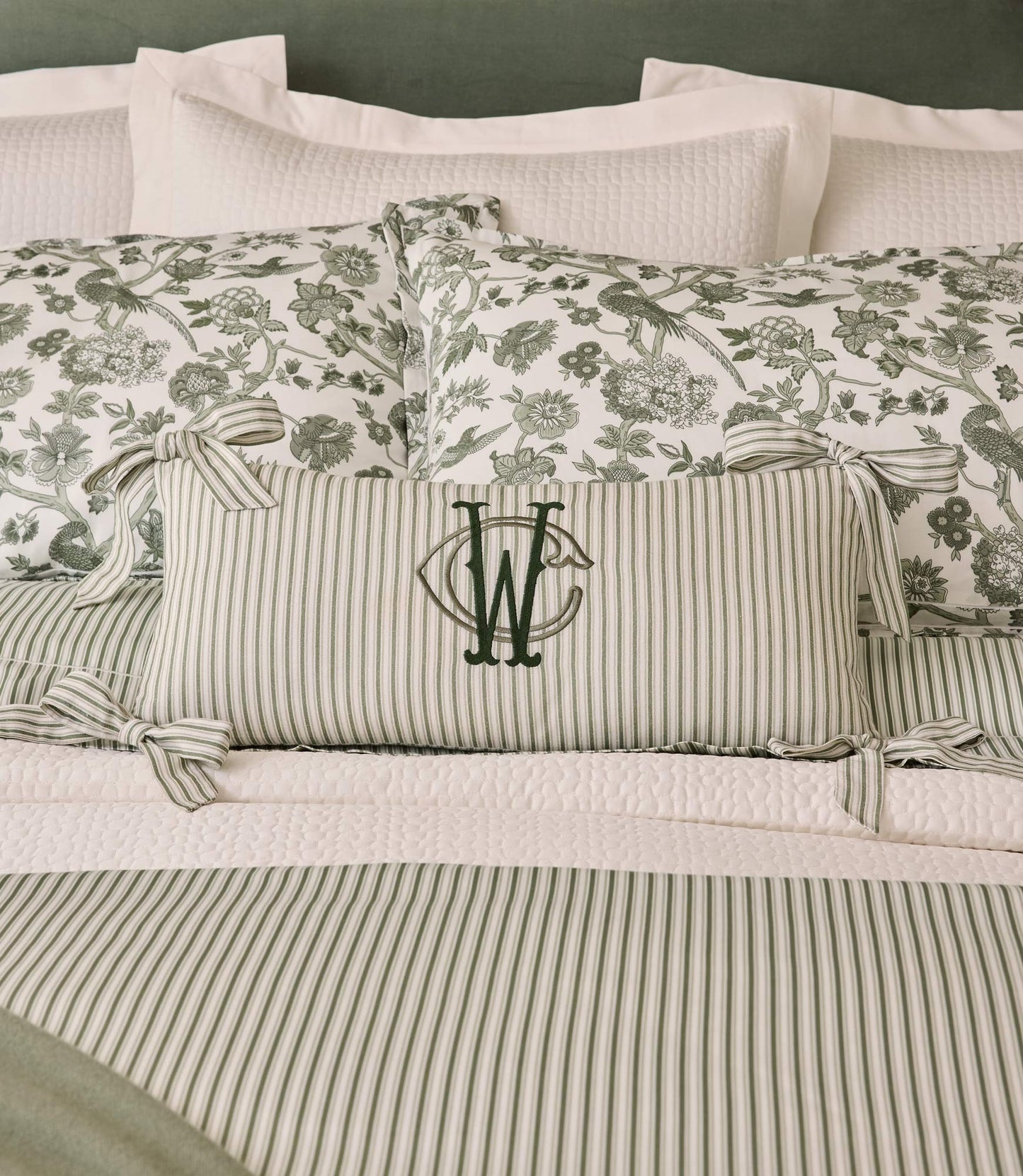 Caitlin Oblong Pillow monogrammed on a green bed, Stripe Moss