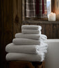 Catalina Bath Towel Set stacked atop a wooden stool, Linen