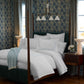 Deco Classic Embroidered Duvet Set on a canopy bed in a room with floral wallpaper and dark wood floors.