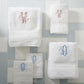 Set of White Diamond Towels with embroidered monograms on a light blue and white tiled background.