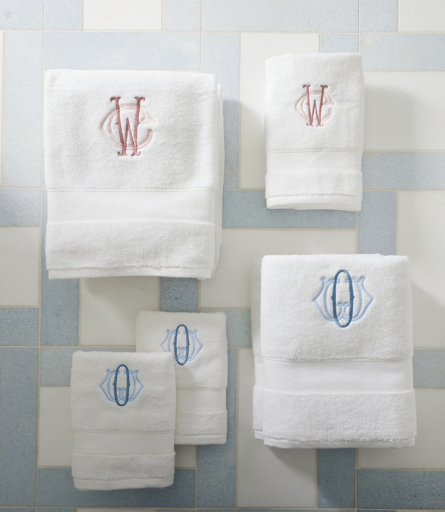 Set of White Diamond Towels with embroidered monograms on a light blue and white tiled background.