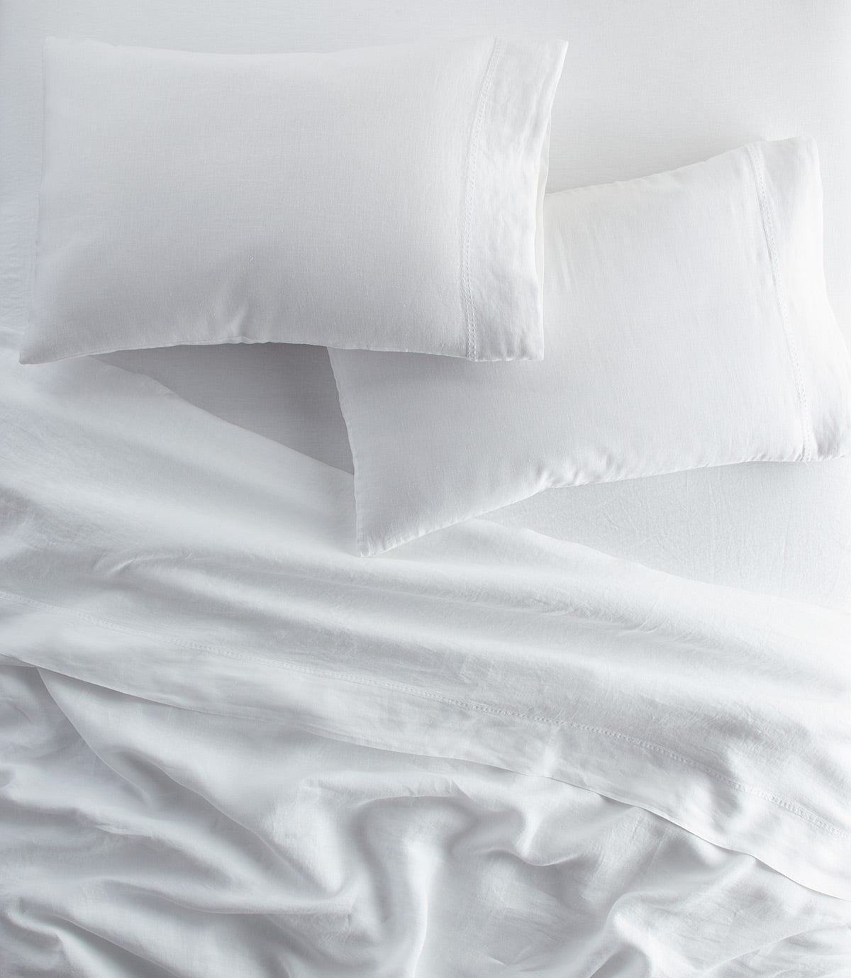 European Washed Linen Pillowcases and sheets on bed, White