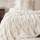 Mila Faux Fur Throw Blanket on bed, Ivory