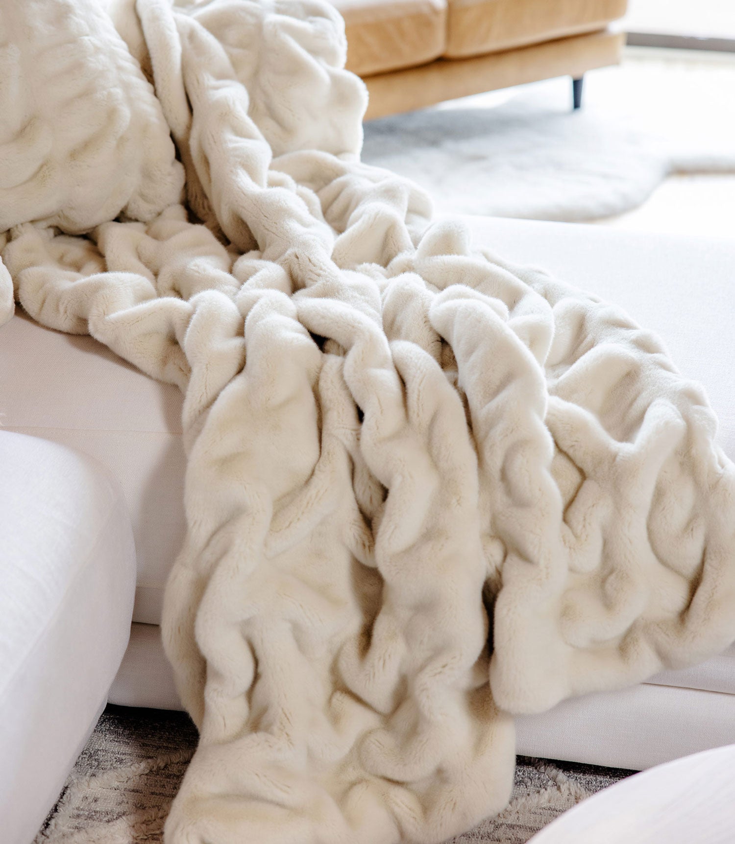 Faux fur blanket laying on couch, Ivory