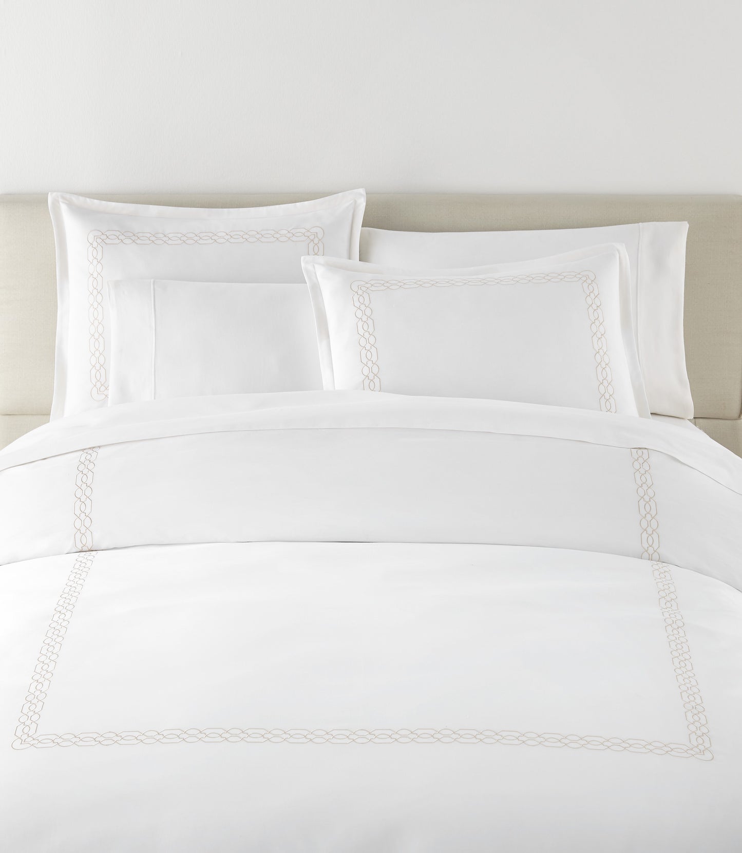 Filigree Duvet Set arranged on a bed against a light beige headboard, Linen