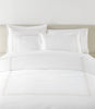 Filigree Duvet Set arranged on a bed against a light beige headboard, Linen