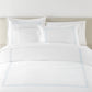 Filigree Duvet Set arranged on a bed against a light beige headboard, Sky