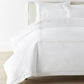 Filigree Duvet Set arranged on a bed against a white wall, Linen