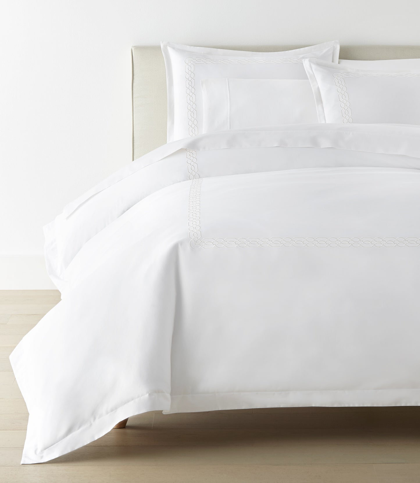 Filigree Duvet Set arranged on a bed against a white wall, White