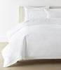 Filigree Duvet Set arranged on a bed against a white wall, White