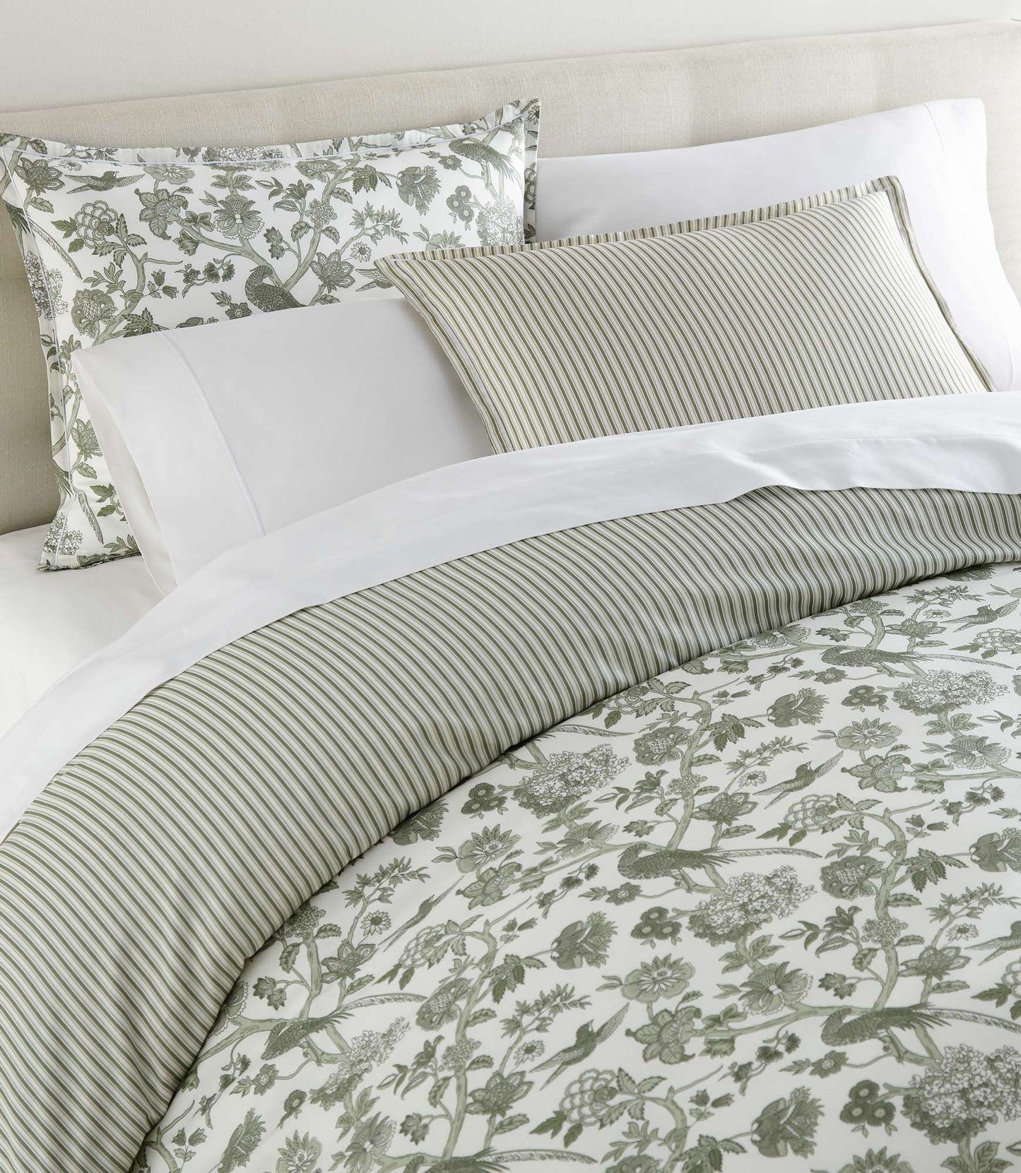 Highgrove Toile Reversible Duvet Set in Highgrove Moss on a bed with a cream colored headboard