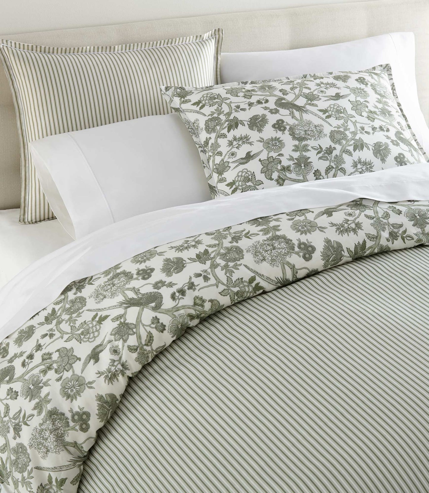Highgrove Toile Reversible Duvet Set in Highgrove Moss on a bed with cream colored headboard