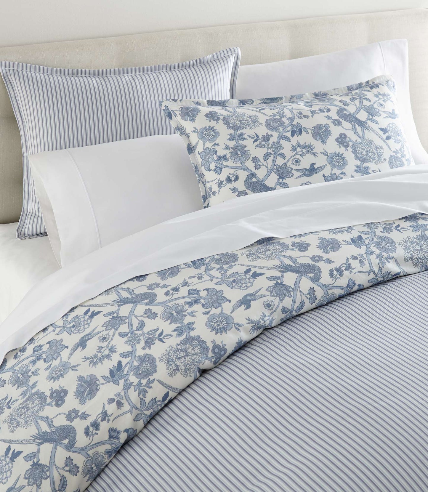 Highgrove Toile Reversible Duvet Set in Highgrove Moss on a bed with cream colored headboard striped