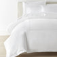 Ivy Classic Embroidered Duvet Set displayed on a bed with a cream colored headboard, White