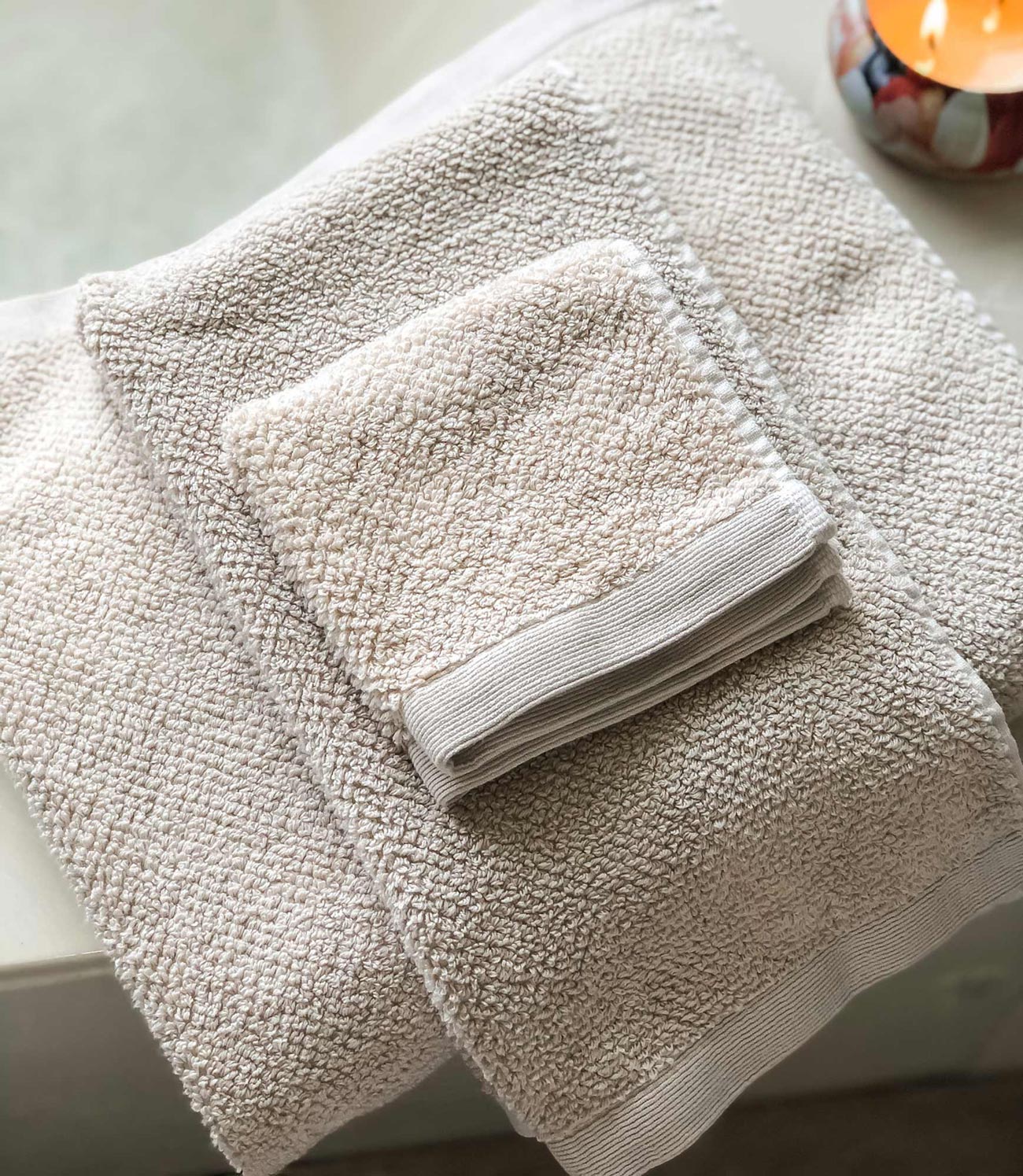 Jubilee Bath Towels folded on bathtub, Linen