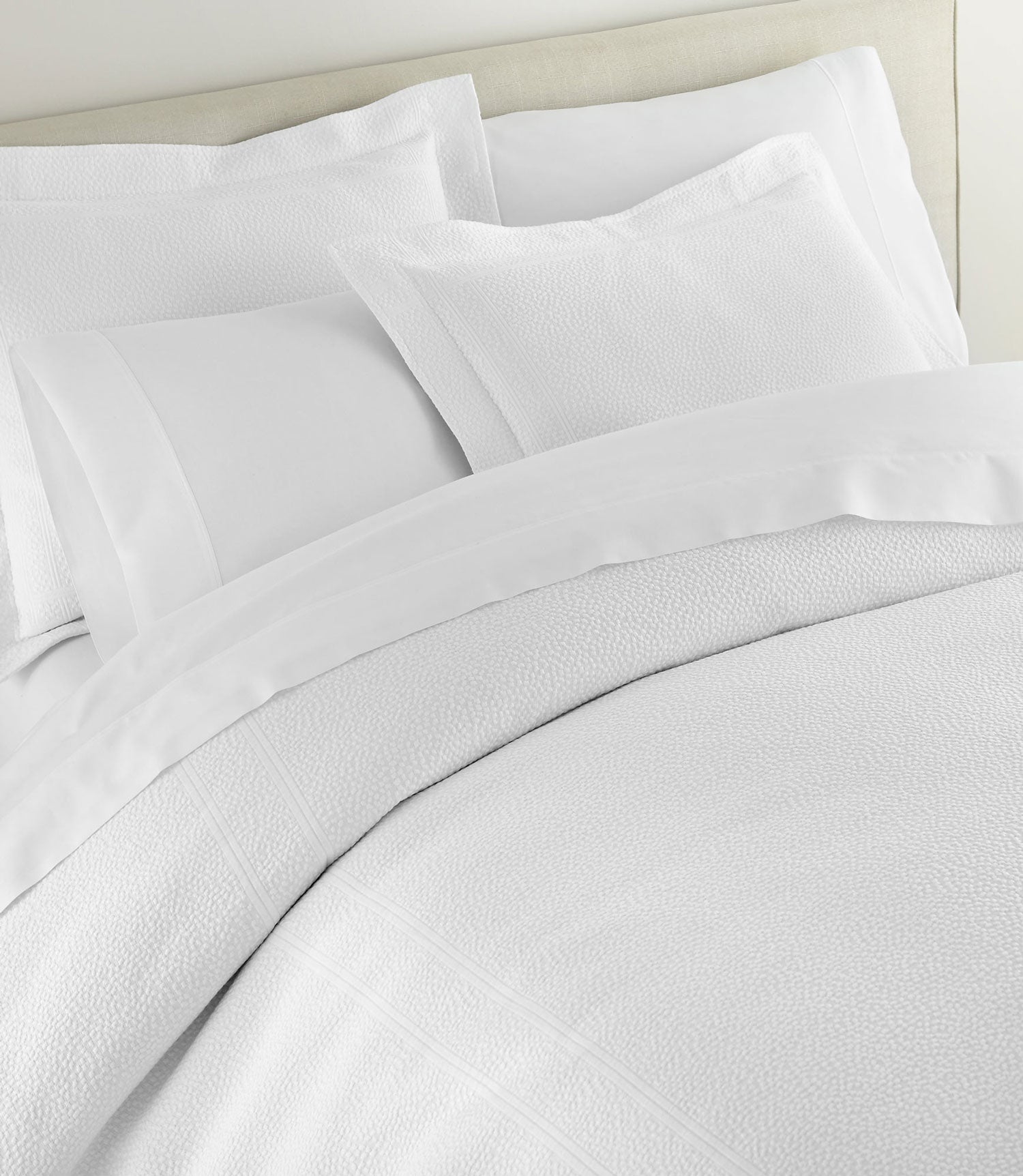 Montauk matelassé duvet cover and shams on bed, White