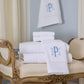 Special Occasion Towels in White with monogram on a decorative chair against a light blue wall.