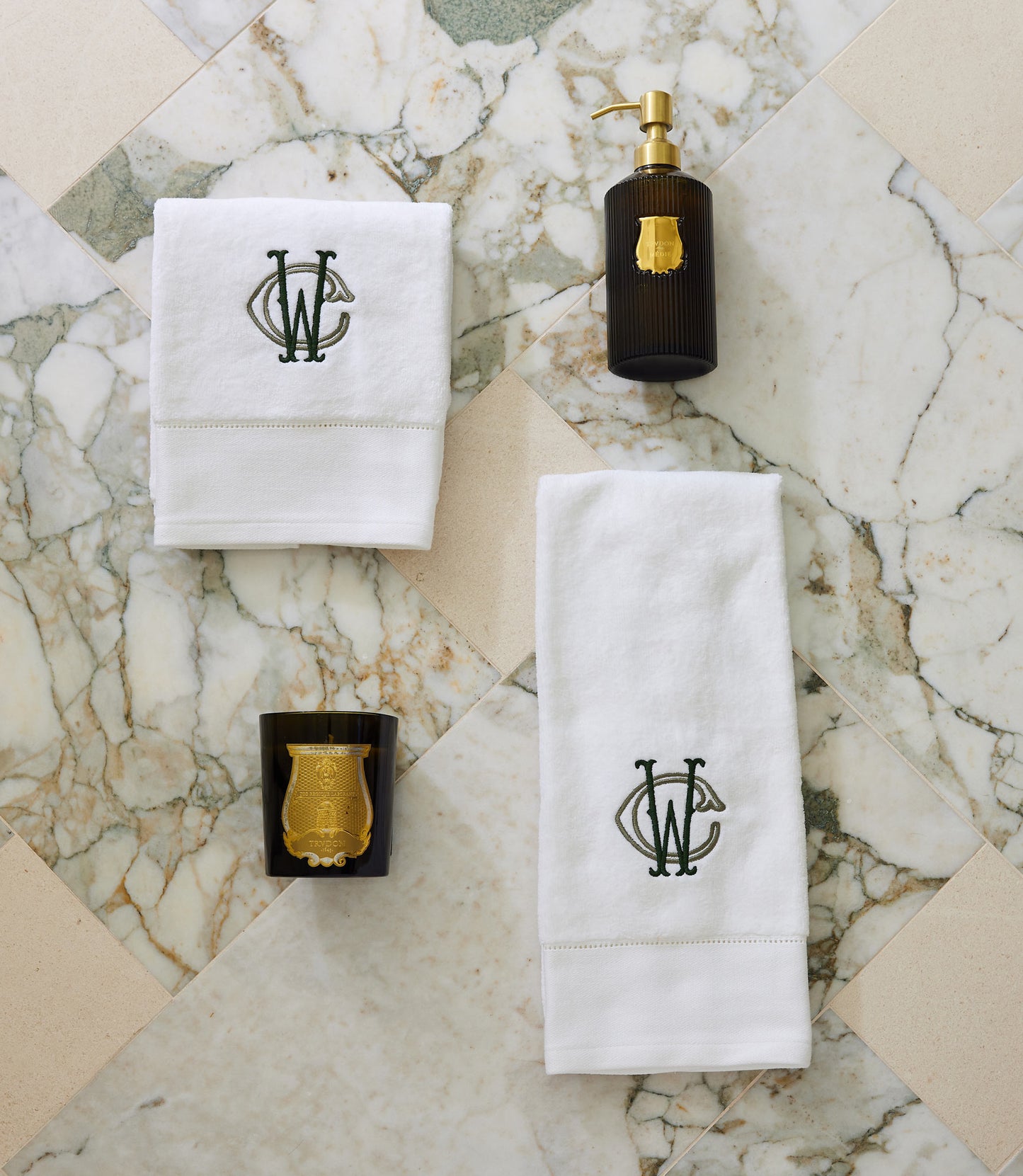 Special Occasion Towel Gift Set in White with monogram design, black soap dispenser, and gold candle on a marble surface 