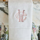 Special Occasion Hand Towel with pink embroidered monogram on a marble surface