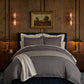 Savoy Jacquard Duvet Set styled in a bedroom on a bed with a dark upholstered headboard, Navy