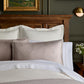 Savoy Jacquard Duvet and Sham styled on a bed with a wooden headboard, Platinum