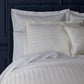 Soprano Striped Sham on a bed with a dark blue headboard