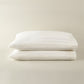 Soprano Stripe Sateen Pillowcases stacked on a beige background, Ivory