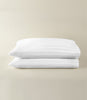 Soprano Stripe Sateen Pillowcases stacked on a beige background, White