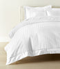 Soprano Stripe Duvet Cover displayed on a bed with a cream colored headboard, White