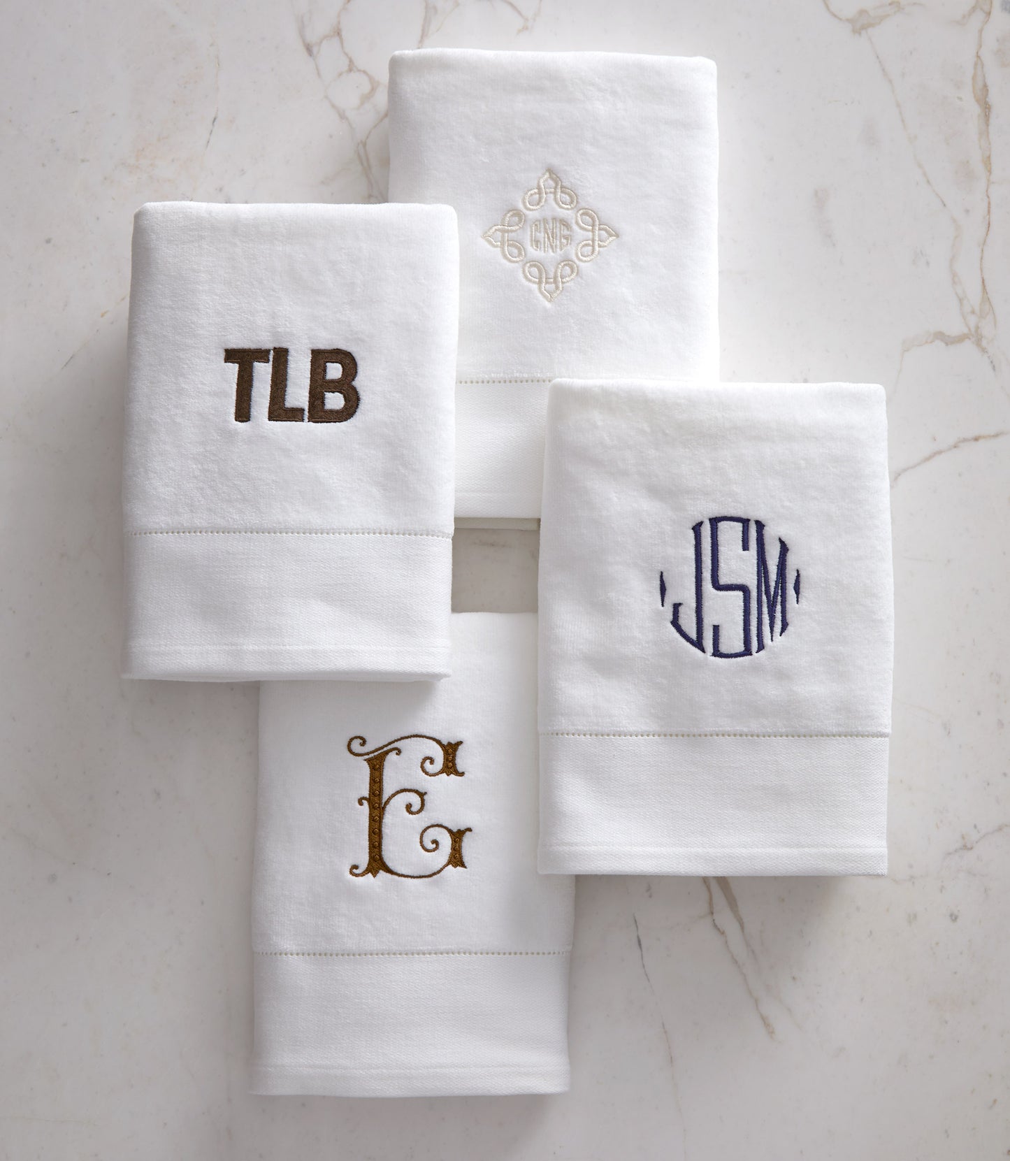Four monogrammed Special Occasion Hand Towel lay flat