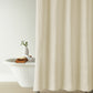 Vienna Matelassé Shower Curtain in a bathroom setting with a white bathtub and decorative items, Ivory