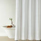 Vienna Matelassé Shower Curtain in a bathroom setting with a white bathtub and decorative items, White