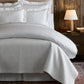 Hamilton Quilted Coverlet on bed in a cabin, White