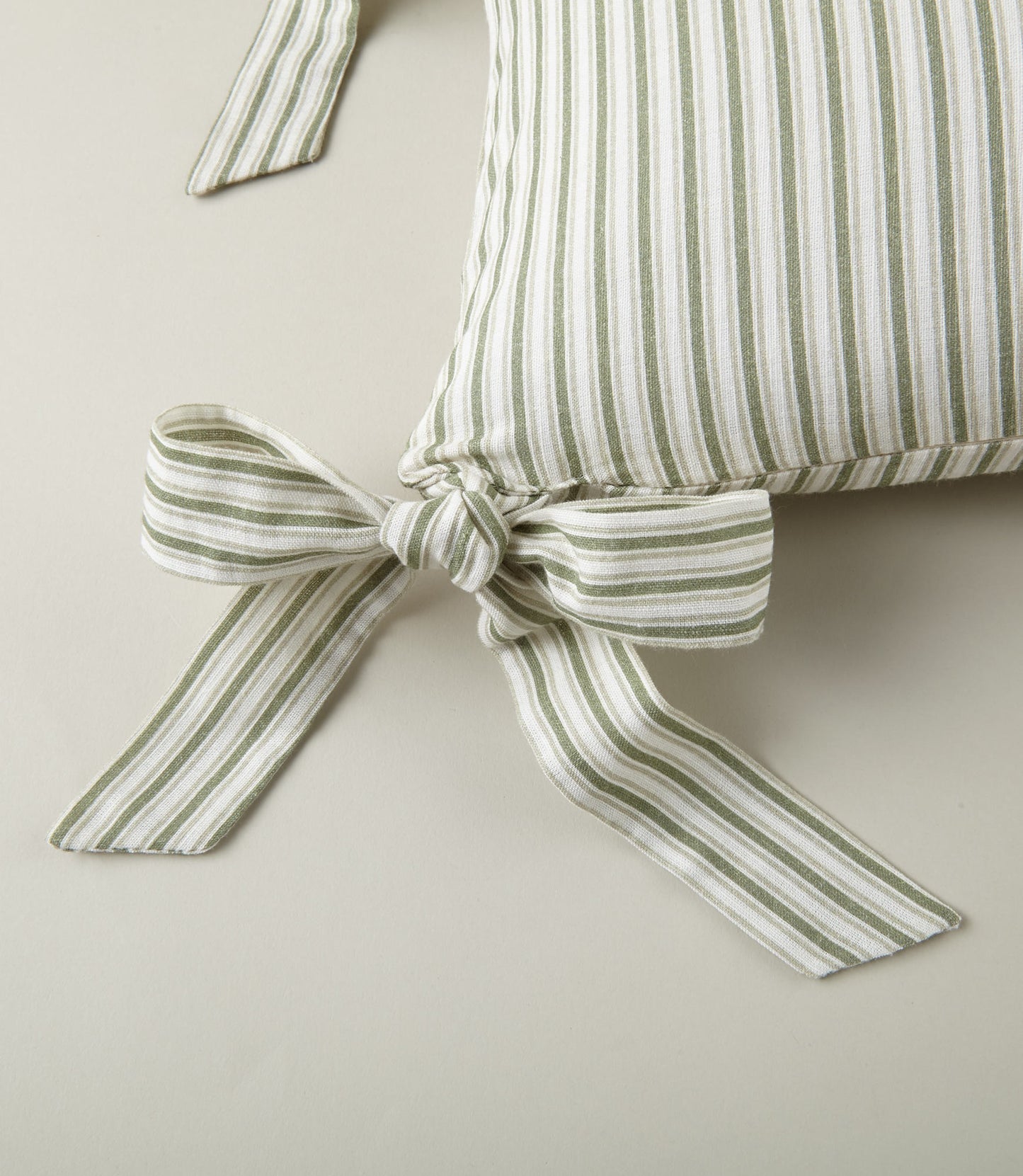 Detail of ribbon ties on the Windsor Stripe Oblong Pillow in Moss